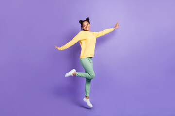 Full size profile photo of optimistic girl jump wear yellow shirt trousers sneakers isolated on lilac color background