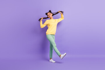 Full size photo of optimistic cool lady go wear yellow sweater trousers sneakers isolated on lilac color background