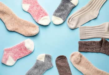 Frame made of warm socks on color background