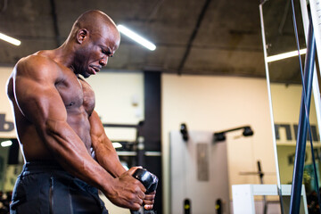 Naklejka premium coach lifting weights over dark background in new gym