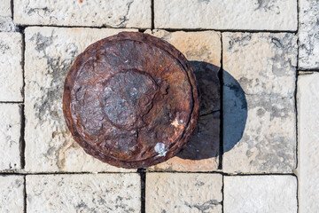 Old rusted mooring bollard on old stone pier background.