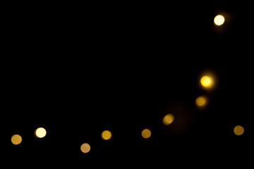 yellow bokeh lights on a black background on a postcard with an empty space for writing.