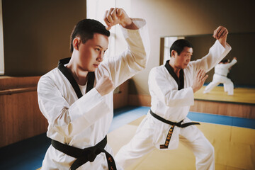 Obraz premium Two men work out tricks while standing in the gym.