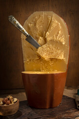 artisan cheeses with dried fruits glass of wine, homemade country bread, bunch of grapes, on wooden board with knife