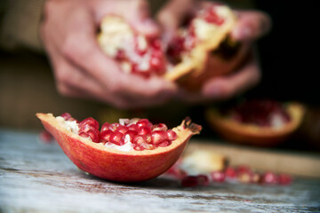 man opening a pomegranate fruit