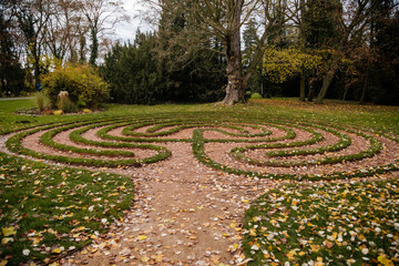 Labyrinth made of gravel and placed in the middle of the lawn in green garden in autumn day, Loucen romantic baroque castle, Czech republic