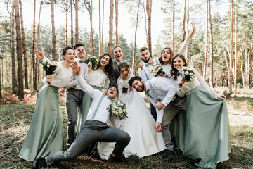 the bride and groom and their friends are having fun and hugging,company of wedding friends having...