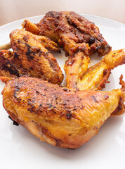 Golden crispy roasted chicken legs and wings with skin macro close up shot pan fried