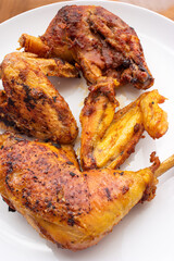 Golden crispy roasted chicken legs and wings with skin macro close up shot pan fried