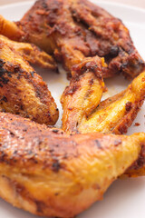 Golden crispy roasted chicken legs and wings with skin macro close up shot pan fried