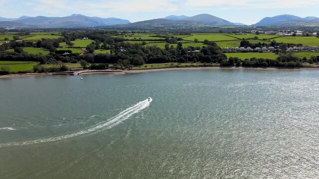 Speed Boat Travelling Along Menai Strait Wales Next To Snowdonia Breathtaking Landscape