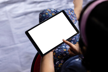 an indian girl child holding tablet with white blank screen in hand