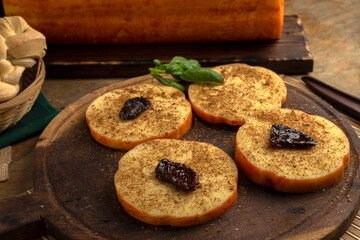 artisan cheeses with dried fruits glass of wine, homemade country bread, bunch of grapes, on wooden board with knife