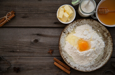 Baking ingredients for baking. There are flour, egg, honey, butter, sugar  on the wooden for baking cookies for christmas. Top view. Copy space for recipe.