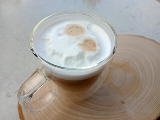 Cappuccino on wooden tray with fresh cream.