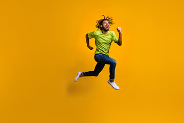 Fototapeta na wymiar Full length photo portrait of excited runner jumping up isolated on vivid yellow colored background