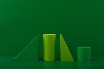 Monochromatic abstract still life with light and dark green geometric figures on a green background...