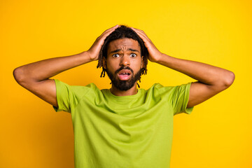 Photo of astonished upset dark skin guy impressed touch hands head isolated over vivid yellow color background