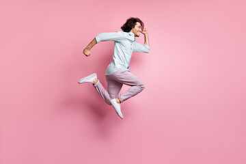 Fototapeta na wymiar Full size profile side photo of young excited man jump wear purple trousers white shoes look copyspace isolated on pink color background