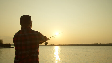 Male angler taking selfie with fish near water