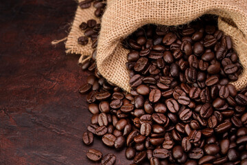 Aromatic roasted coffee beans placed on a needle-colored table - top view with copy space.