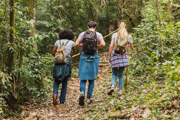 Friends with backpacks walking in the countryside - Group of walking friends walking in the jungle.