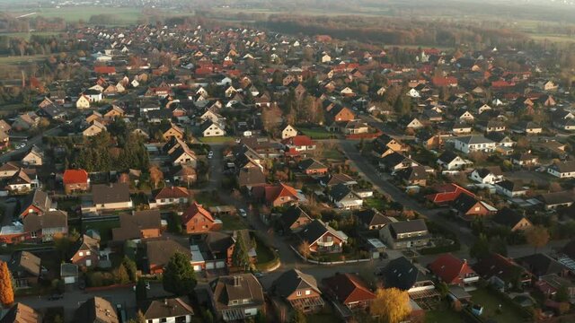 Aerial view, pan over a village in Germany with traditional single family houses on small garden plots