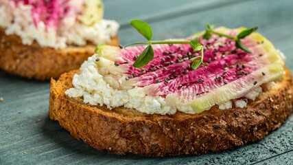 toasts from sliced watermelon radish with chinese daikon, cottage cheese and microgreen. Food recipe background. Close up