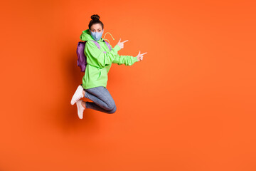 Fototapeta na wymiar Full size portrait of model jump indicate empty space wear sweater bag jeans shoes isolated on orange color background