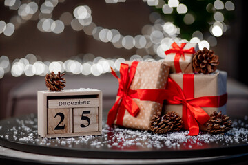 wooden calendar date 25 december with gifts, snow and pine cones in anticipation of christmas in cold color, happiness concept