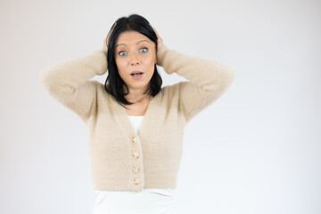 Portrait of young woman with shocked facial expression over white background.