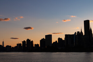 Fototapeta na wymiar Silhouette of the Manhattan Skyline along the East River during a Beautiful Sunset in New York City