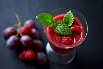 Fresh smoothie in a glass. Dark background. Close up.	