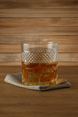 Glass of whiskey on a wooden background