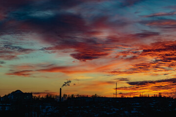 High and wide chimney, a pipe with a large amount of smoke and substances released into the atmosphere. Part of a factory or enterprise that pollutes the environment in a snowy and frosty winter near 