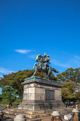 Obraz premium 皇居外苑に立つ楠木正成公騎馬銅像。斜め正面の角度。順光。背景は青空。 楠木正成は鎌倉時代末期から南北朝時代に活躍し、後醍醐天皇に忠誠を尽くした武将。銅像は明治33年、西暦1900年に作られた。