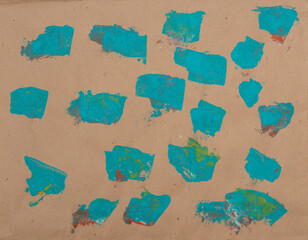 Paint spots isolated on old recycled paper. Turquoise color on brown background.