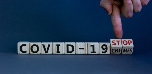 Stop covid-19 crimes. Hand turns cubes with words 'stop covid-19 crimes'. Beautiful grey background. Business and covid-19 pandemic concept. Copy space.