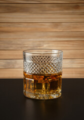 Glass of whiskey on a wooden background