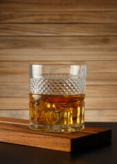 Glass of whiskey on a wooden background