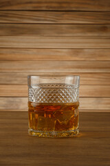 Glass of whiskey on a wooden background