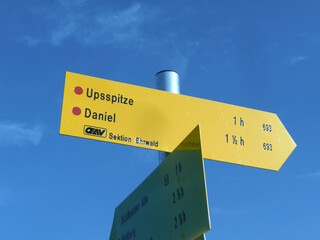 Sign post Upsspitze and Daniel mountain at Ammergau Alps, Tyrol, Austria