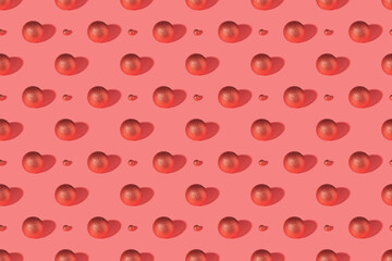 Red shiny Christmas baubles on a pink pastel background. Christmas decorations. Minimal composition seamless pattern background. Christmas and New year concept. Top view, flat lay