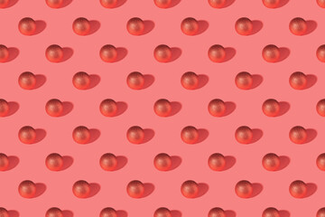 Red shiny Christmas baubles on a pink pastel background. Christmas decorations. Minimal composition seamless pattern background. Christmas and New year concept. Top view, flat lay