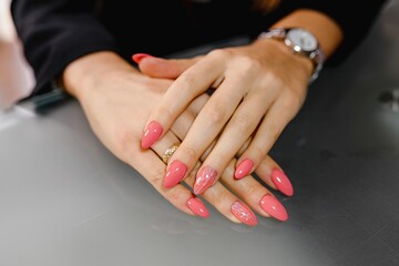 Close up woman hand showing pink polish. Nail art styling, beauty, manicure concept.