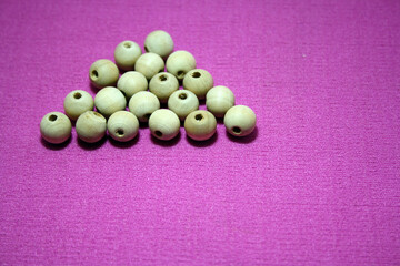 White beads spread on pink background.