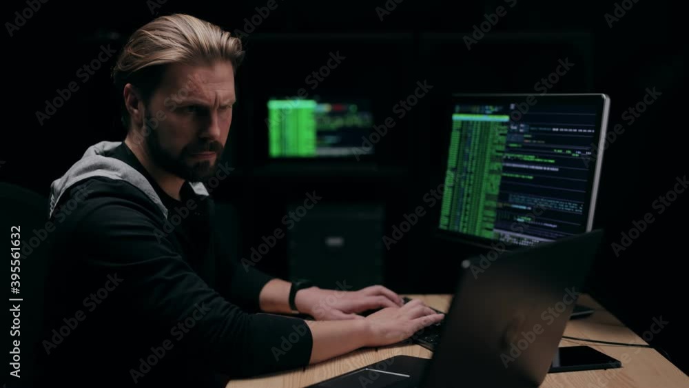 Poster software developer working on project in dark room, computer monitors glowing, security service