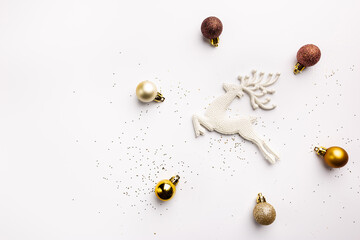 Christmas gold decorations and deer on white background, top view. Winter Decoration Background