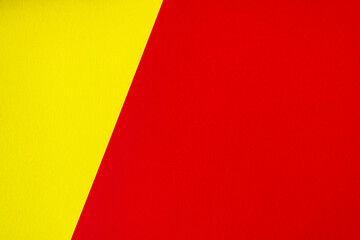 Fototapeta premium Beautiful background of two unequal parts yellow and red. Sheets of blank yellow and red paper with fine texture separated by a sloping border.