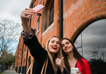 Two young friends taking a selfie with mobile phone.